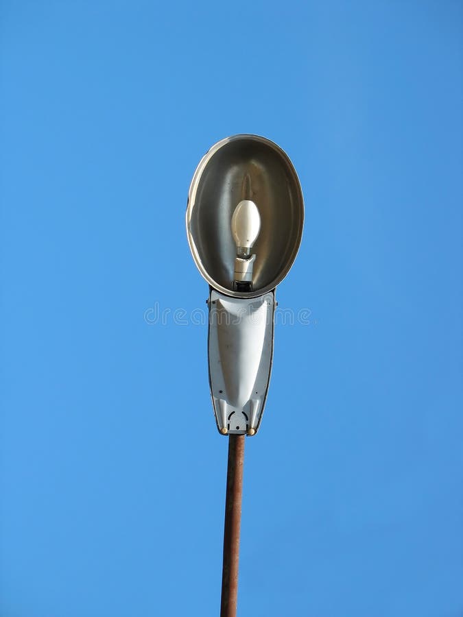 Closeup of street light lamp against a blue sky