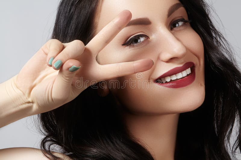 Closeup studio portrait of beautiful young woman with gesturing peace. Perfect style and make-up. happy toothy smile royalty free stock images Closeup studio portrait of beautiful young woman with gesturing peace. Perfect style and make-up. happy toothy smile royalty free stock images
