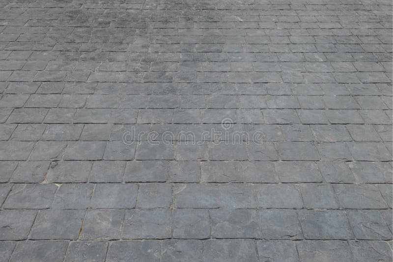 Closeup surface brick pattern at old black stone brick floor at pathway texture background