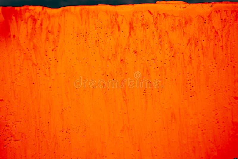 Closeup of a Surface with the Dripping Bright Orange Paint with Small