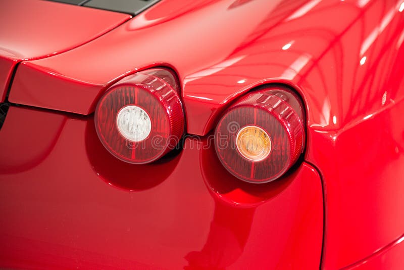 Closeup of the Tail Lights of a Red Modern Luxury Car Under the Lights