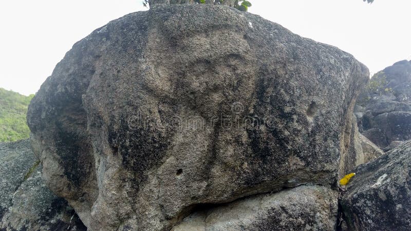 Closeup to an ancient petroglyph of human face at Colombian San Agustin archaeological park.