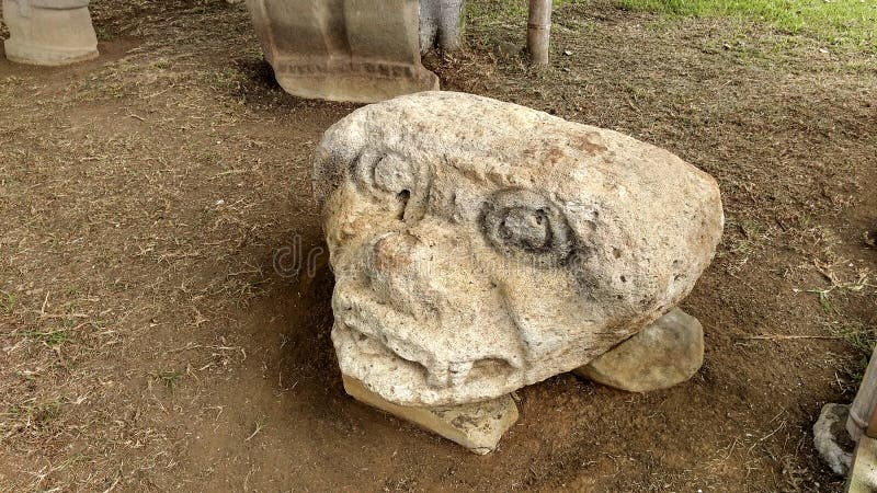 Closeup to an ancient sculpture of an anthropo-zoomorphic head Colombian San Agustin archaeological park.