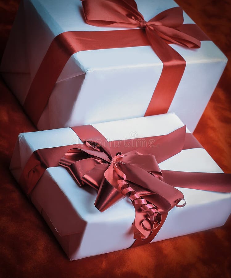 Elegant Gift Boxes with Red Satin Ribbon Wrapped in Paper. Stock Photo