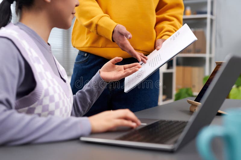 Closeup of two young people discussing document royalty free stock photo