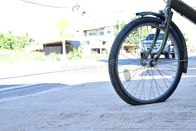 Bicycle with a Flat Rear Wheel in a City Park Closeup. Bicycle Wheel