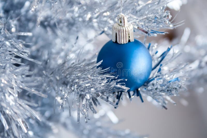 Closeup view of a blue matte ball hanging on a silver artificial Christmas tree. Selective focus. Blurred background royalty free stock photos Closeup view of a blue matte ball hanging on a silver artificial Christmas tree. Selective focus. Blurred background royalty free stock photos