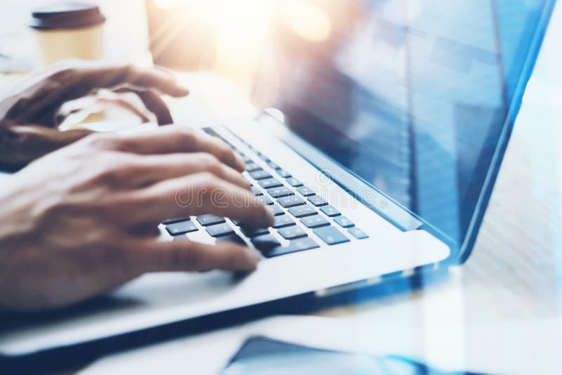 Closeup view of businessman working at sunny office on modern laptop. Male hands typing on notebook keyboard. Blurred royalty free stock photos