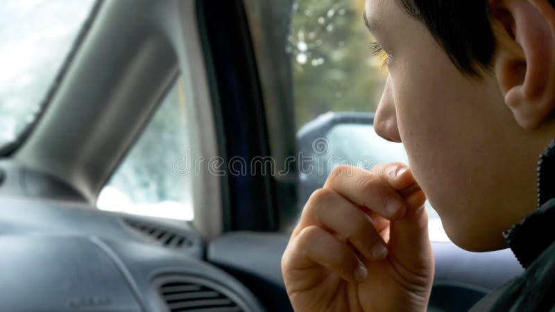 Closeup view child boy hand holding and eating biscuits while traveling in car