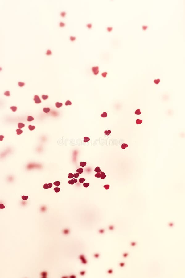Closeup view of confetti hearts of red color against pink background. royalty free stock image Closeup view of confetti hearts of red color against pink background. royalty free stock image