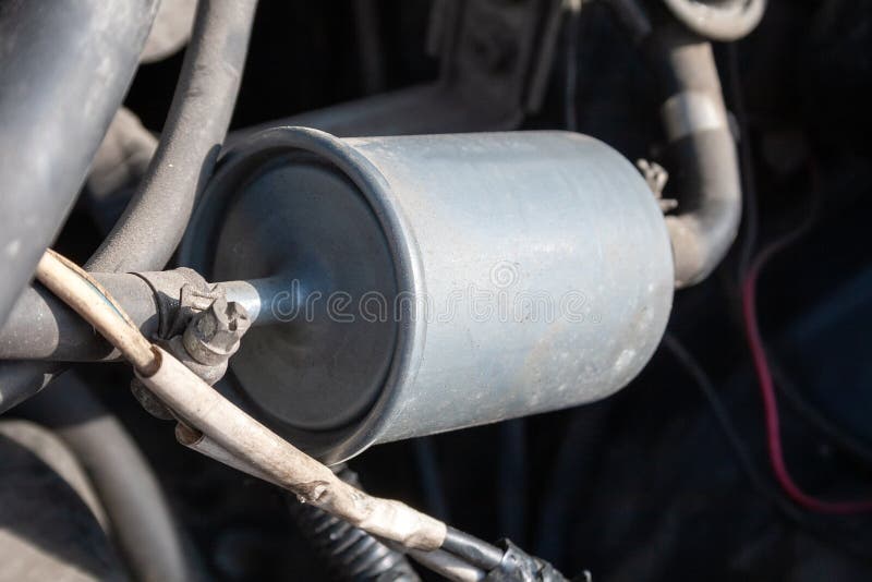 A Closeup View of a Fuel Filter Installed in a Car with a Fuel Line