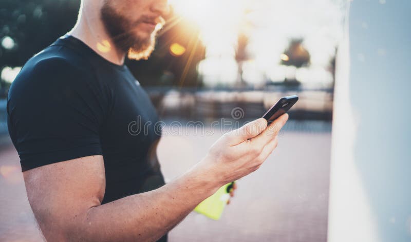 Closeup view of Muscular handsome athlete checking sport results on smartphone application and smart watch after good stock photos Closeup view of Muscular handsome athlete checking sport results on smartphone application and smart watch after good stock photos