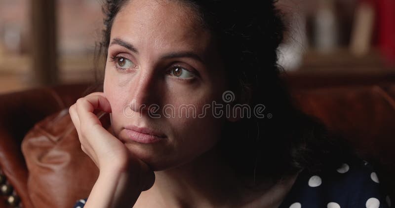 Closeup view sad pensive woman sit on couch at home