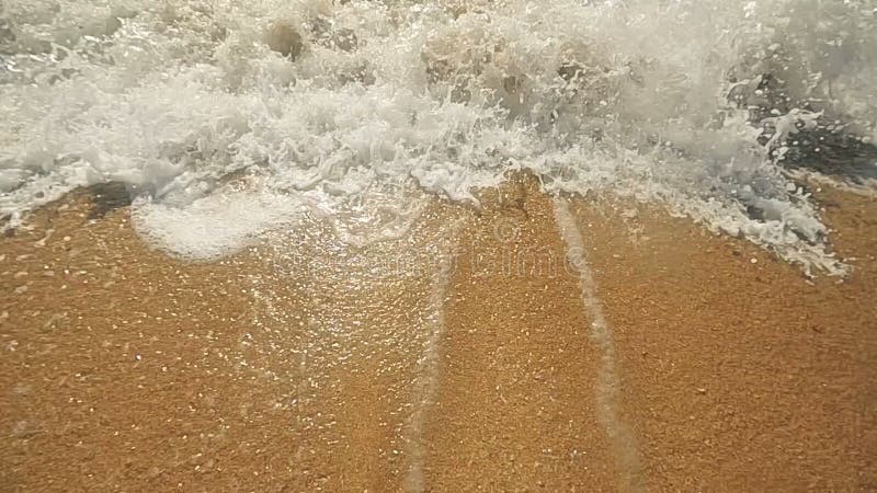 Closeup Waves of the Sea on the Sandy Beach. Sun Reflection in Sea Water Slow Motion