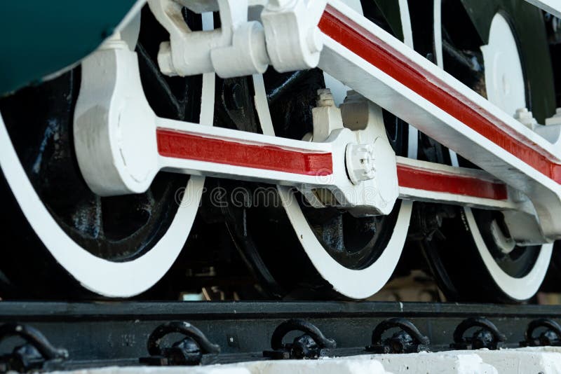 Closeup wheel of train. Green red and white train. Antique vintage train locomotive. Old steam engine locomotive. Black locomotive