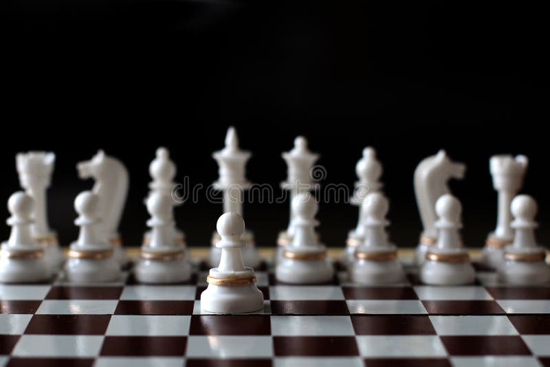 Premium Photo  Closeup of chess pieces on the chessboard under the lights  with a blurry background