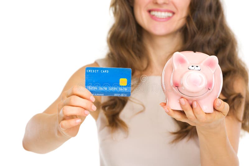 Closeup on woman with credit card and piggy bank