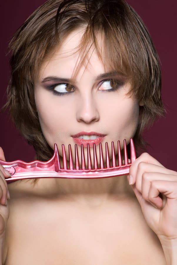 Closeup woman with hairbrush on red background