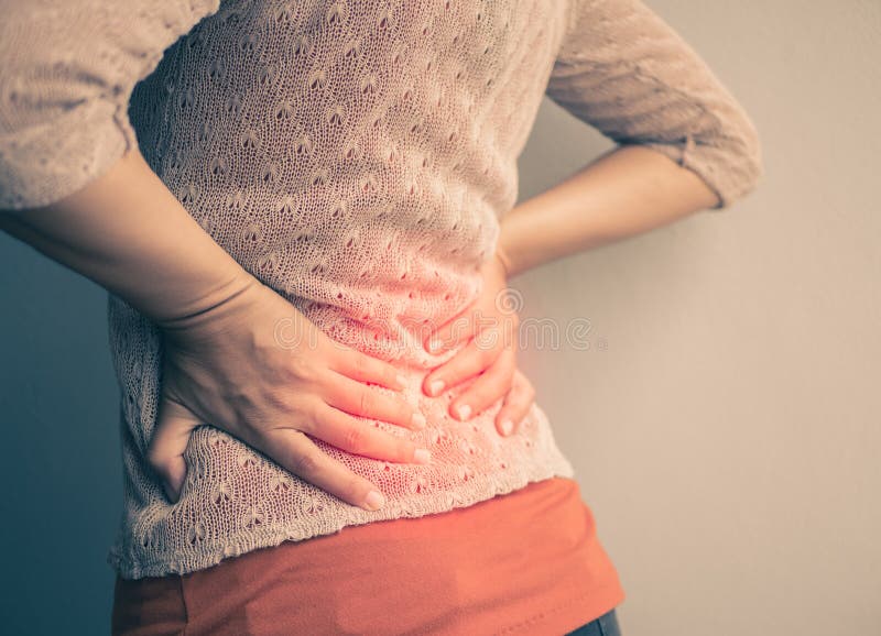 Closeup woman with hands holding her waist back in pain.