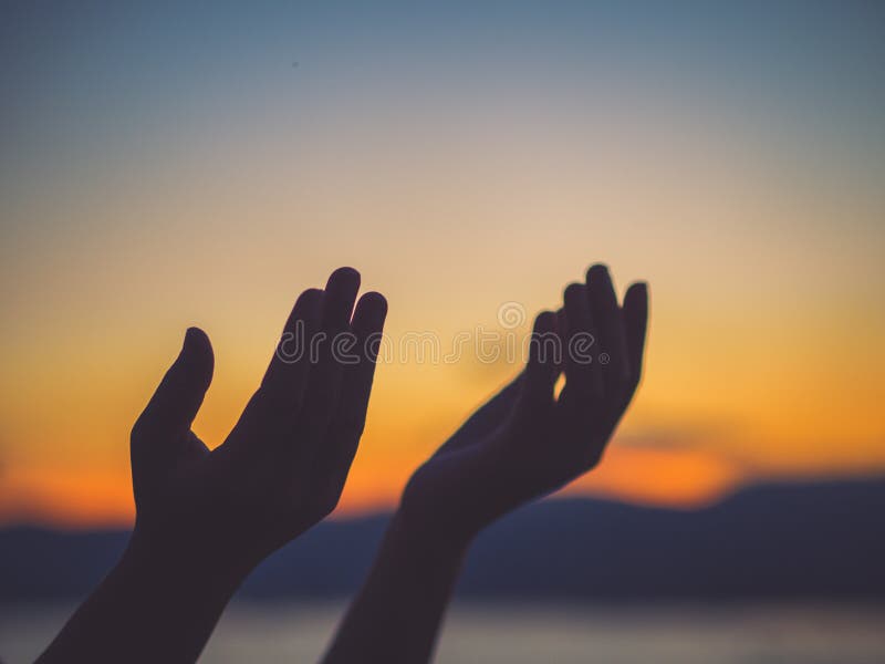 Closeup woman hands praying for blessing from god during sunset