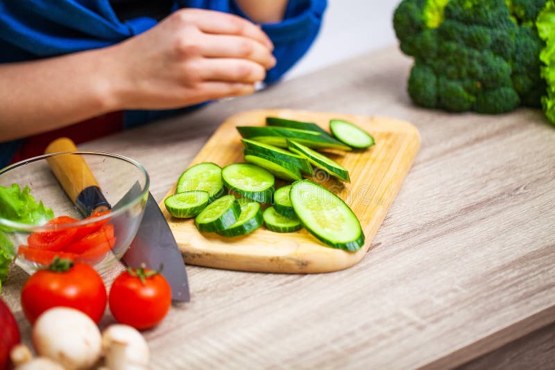 Closeup of woman slices cucumber for diet salad royalty free stock photo Closeup of woman slices cucumber for diet salad royalty free stock photo