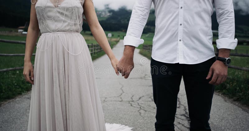 Closeup young couple dressed romantic are holding the hands of a each other background amazing nature view