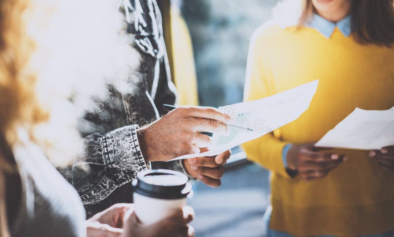 Closeup of young coworkers team making great business discussion in sunny office near the window.Man holding a paper in stock images Closeup of young coworkers team making great business discussion in sunny office near the window.Man holding a paper in stock images