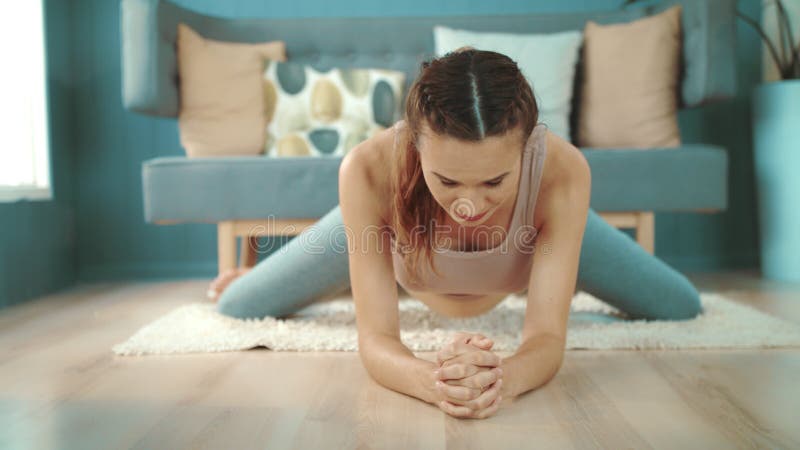 Closeup young pregnant woman making yoga exercises on floor.