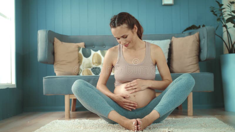 Closeup young pregnant woman relaxing after worout at home.