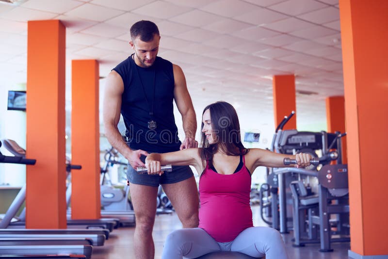 Young pregnant woman lifting dumbbells on fitball stock photography Young pregnant woman lifting dumbbells on fitball stock photography