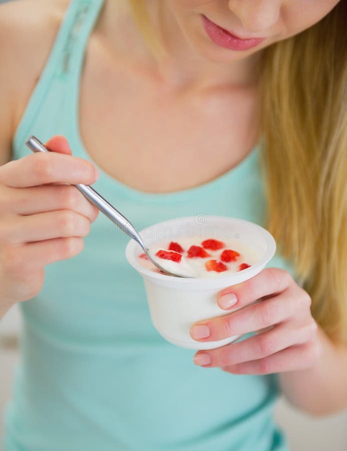 Closeup on young woman eating yogurt stock photo Closeup on young woman eating yogurt stock photo