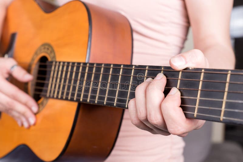 Closeup of young woman hand playing acoustic guitar royalty free stock photography Closeup of young woman hand playing acoustic guitar royalty free stock photography