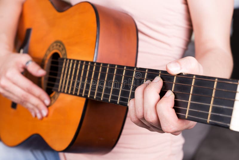 Closeup of young woman hand playing acoustic guitar stock image Closeup of young woman hand playing acoustic guitar stock image