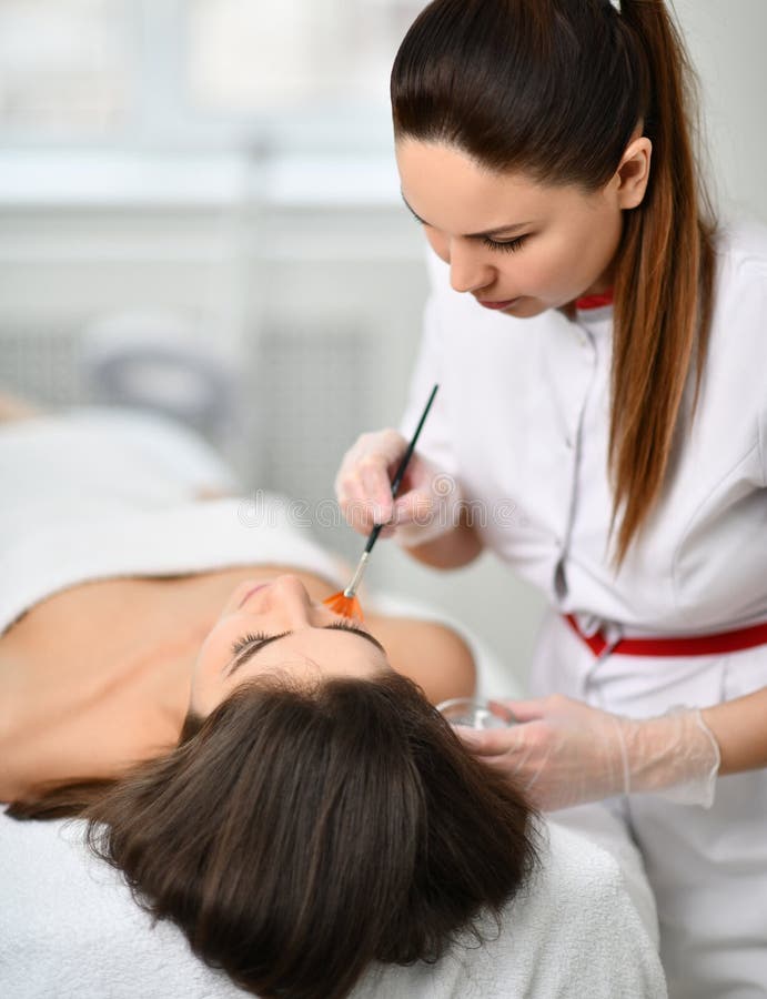 closeup Το Cosmetician προετοιμάζει τον ασθενή για μια καλλυντική διαδικασία Εφαρμόζει ήπια μια σύνθεση με μια βούρτσα στοκ φωτογραφία closeup Το Cosmetician προετοιμάζει τον ασθενή για μια καλλυντική διαδικασία Εφαρμόζει ήπια μια σύνθεση με μια βούρτσα στοκ φωτογραφία