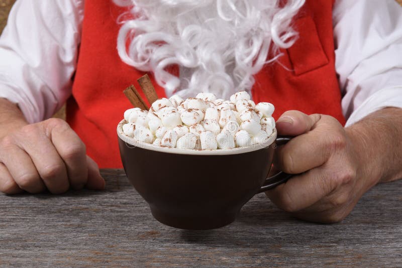 Closeupen av Santa Claus som rymmer, rånar av varm ny varm kakao med marshmallower
