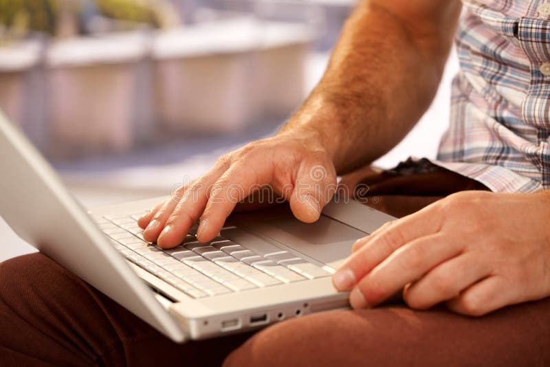Closeupfotoet av mannen räcker maskinskrivning på bärbara datorn arkivbild Closeupfotoet av mannen räcker maskinskrivning på bärbara datorn arkivbild