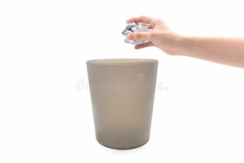 Closeupkvinnahand som kastar papper i brunt avfallfack royaltyfri bild Closeupkvinnahand som kastar papper i brunt avfallfack royaltyfri bild