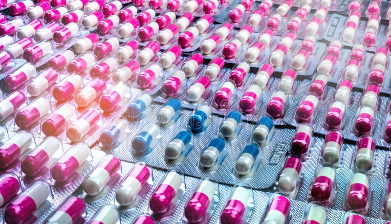 Closeuprosa färg-vit och blåvita antibiotikummar capsule preventivpillerar i blåsapacke Antimicrobial drogmotstånd farmaceutiskt royaltyfri fotografi