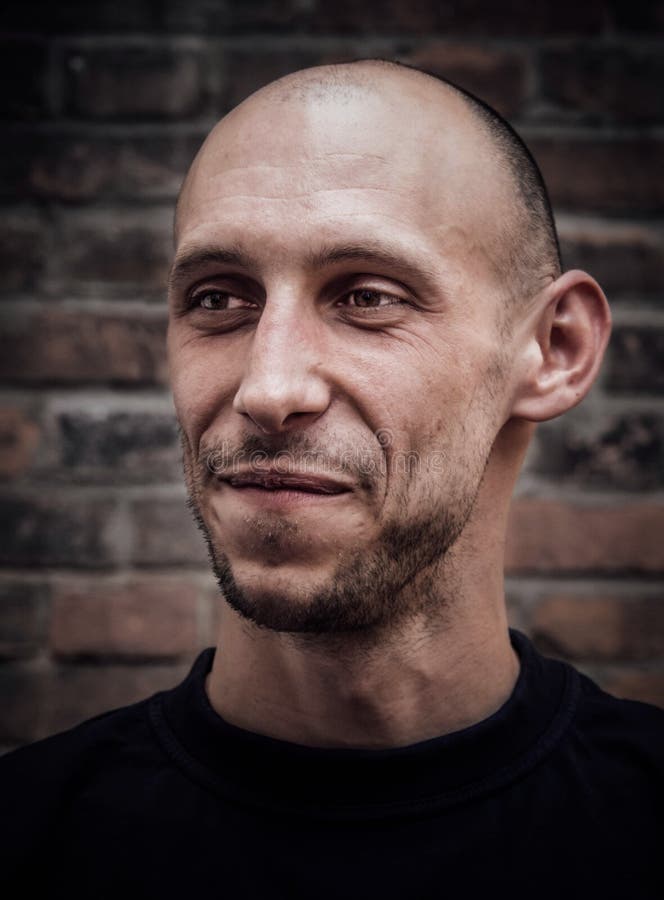 Closeupstående av en skallig man med ett leende och ett brutalt utseende fotografering för bildbyråer Closeupstående av en skallig man med ett leende och ett brutalt utseende fotografering för bildbyråer