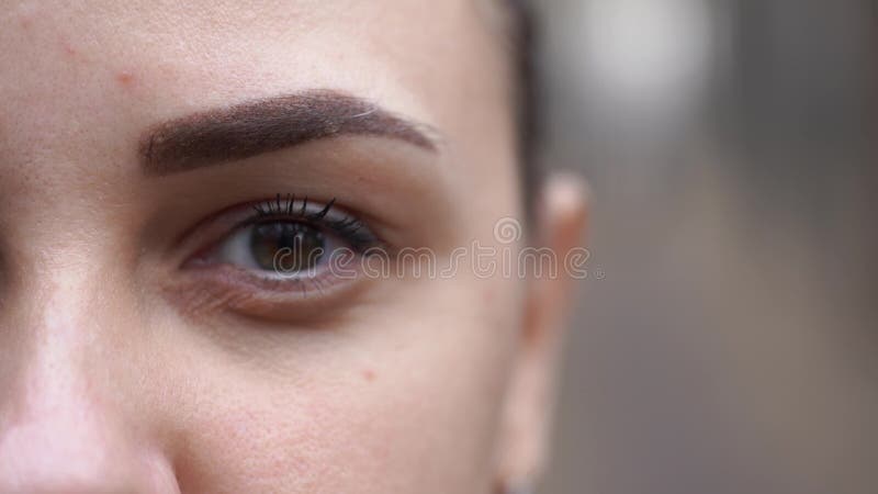 Closeuse de femmes oeil sur fond flou. jeune femme qui clignote.