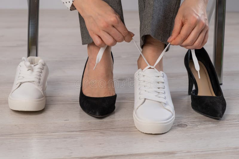 Closeuse Femme D'affaires Enlève Ses Chaussures Met Des Baskets En Cuir  Blanc. Image stock - Image du confortable, commencez: 223693309