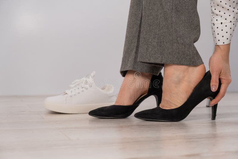 Closeuse Femme D'affaires Enlève Ses Chaussures Met Des Baskets En Cuir  Blanc. Image stock - Image du confortable, commencez: 223693309