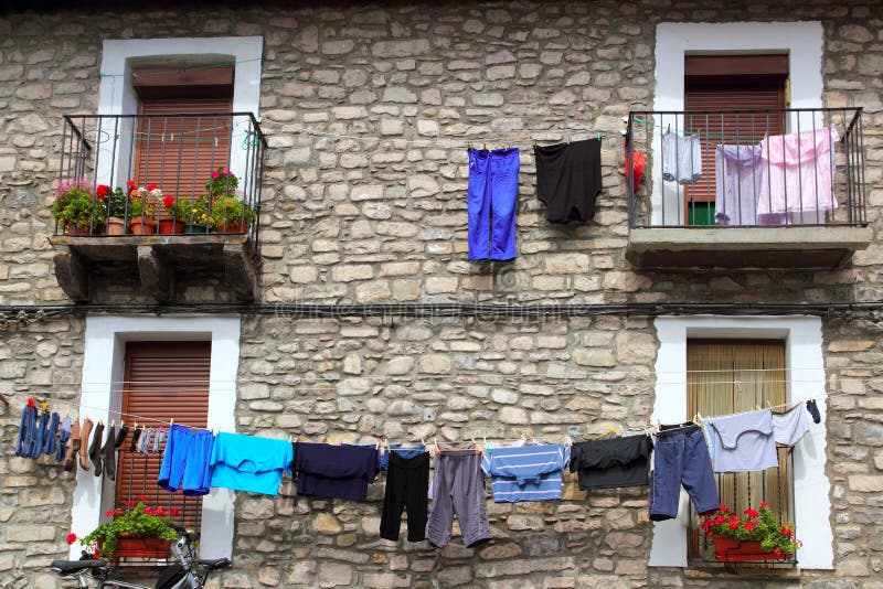 Clothes line hanging from stone wall houses