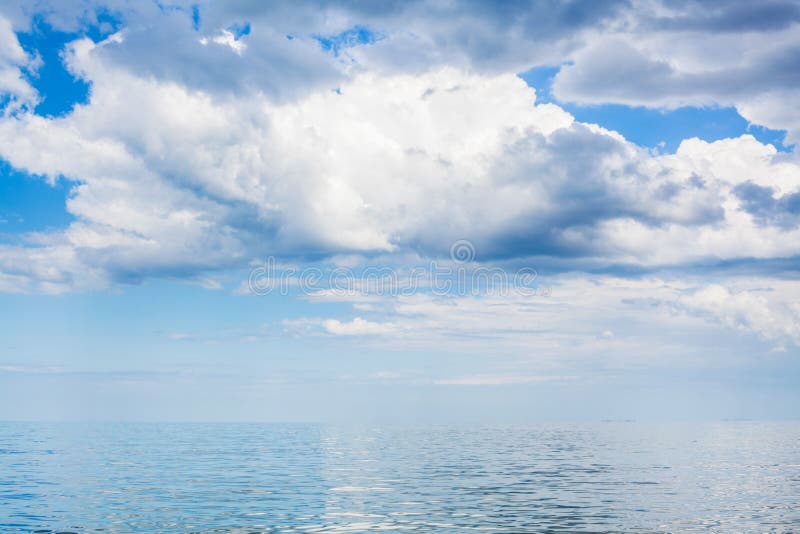 Clouds in blue sky over calm water of Azov Sea