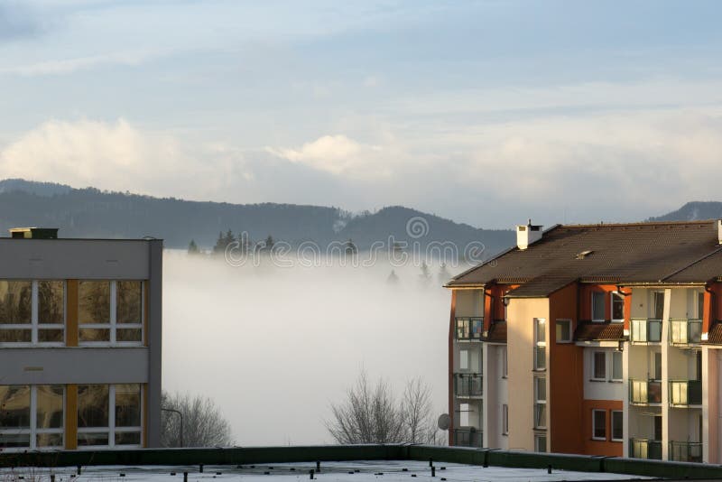 Clouds inversion on the meadow and around the town.