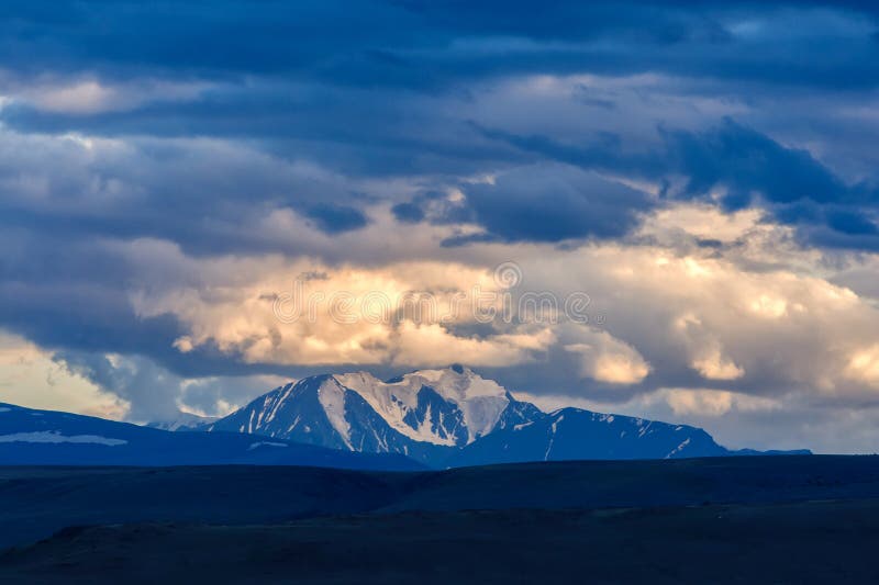 Clouds passing over mountain pinnacle in sunset light royalty free stock photos