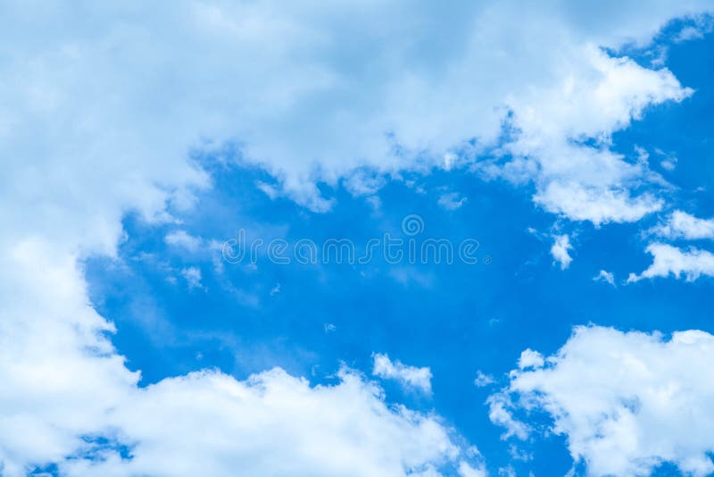 Clouds passing by a very blue summer sky. royalty free stock image