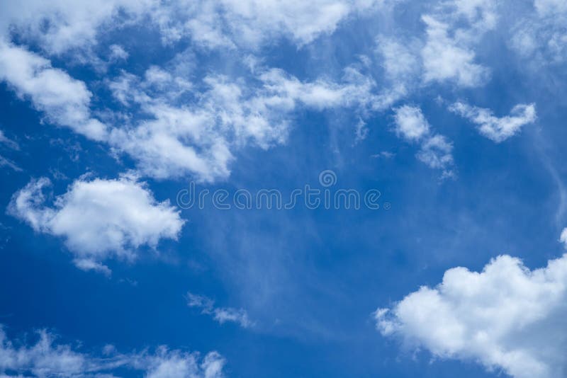 Clouds passing by a very blue summer sky. stock image