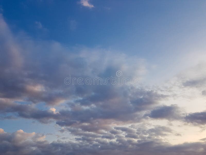 Cloudscape härliga moln och blå himmel i den guld- timmen royaltyfria foton