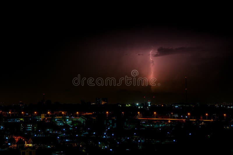 Cloudy with Bright lightning bolt strikes in the rural landscape of small city and satellite station. The Cloudy with Bright lightning bolt strikes in the rural stock image Cloudy with Bright lightning bolt strikes in the rural landscape of small city and satellite station. The Cloudy with Bright lightning bolt strikes in the rural stock image